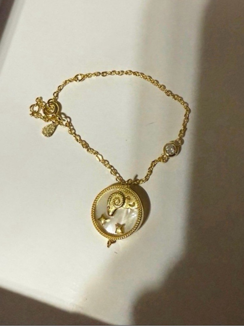 Aries Ram mother of pearl bracelet with topaz accent stone.